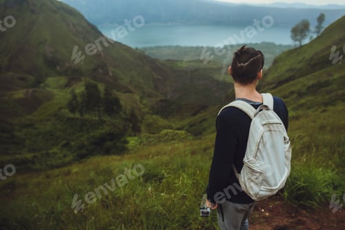 Preview: Modern Hiker man looking at sunrise on the mountain,freedom concept.