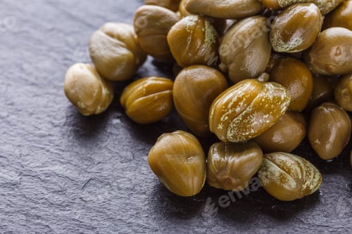 Preview: pickled capers on a dark stone background