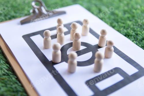 Preview: Football tactical clipboard on top of green football field.