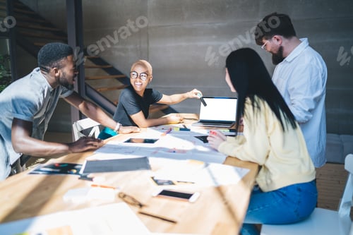 Preview: Excited colleagues working with laptop during meeting