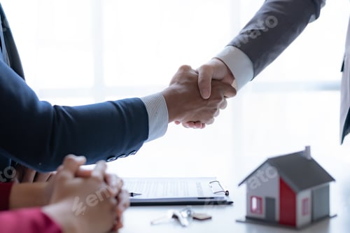 Preview: Real estate agent shaking hands with a client to sign a home purchase contract and congratulate