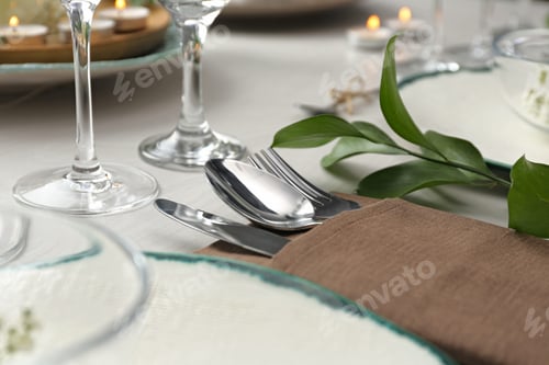 Preview: Elegant cutlery with green plant on table, closeup. Festive setting