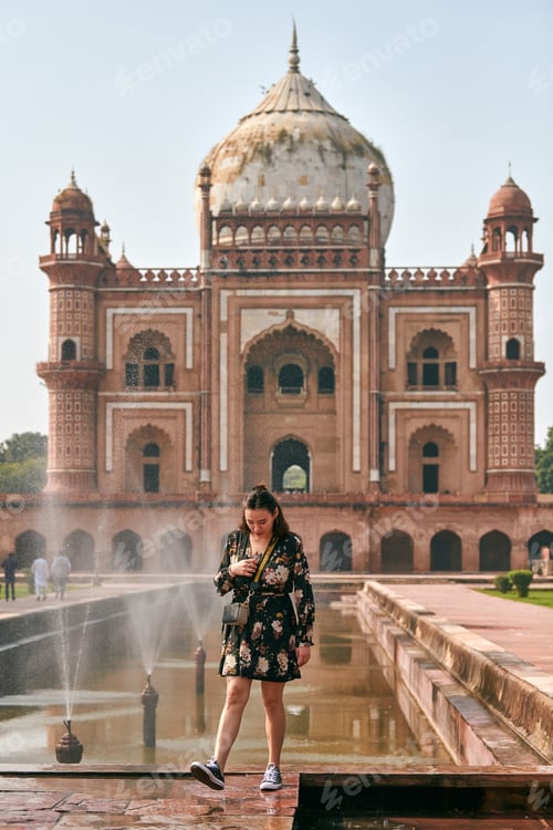 Preview: Attractive east asian woman in dress stands in front of tomb of Safdar Jang in New Delhi, India