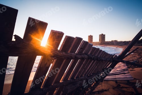 Preview: Sunset at the beach between pieces of wood