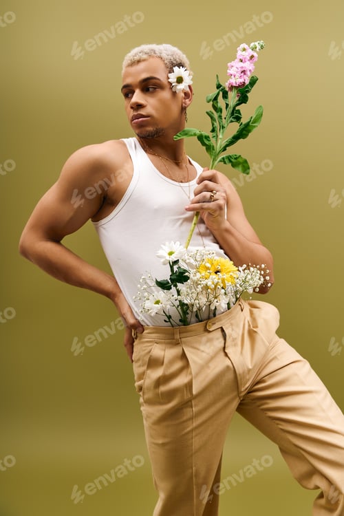 Preview: Young man showcases vibrant style with flowers in trendy studio setting