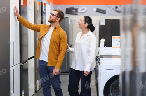 Preview: family couple buying domestic refrigerator in supermarket