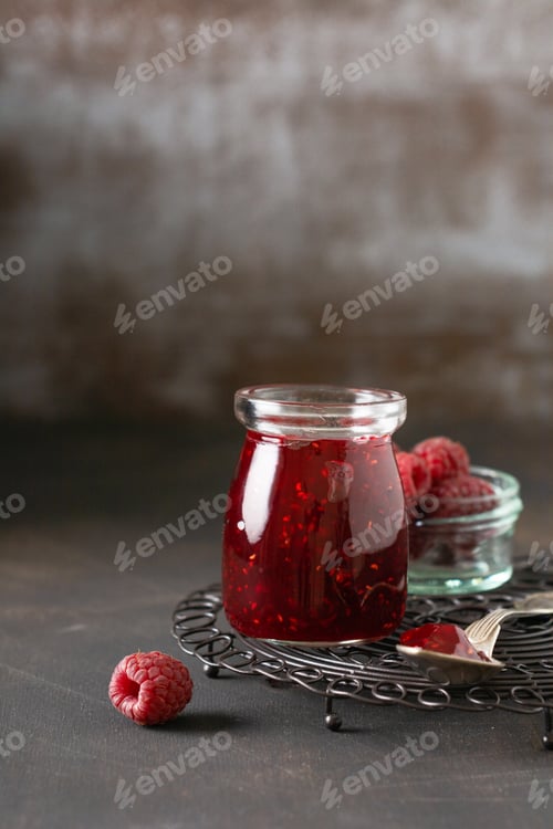 Preview: Raspberry jam in a glass jar with fresh raspberry berries on the old retro background.