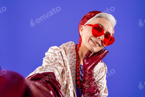 Preview: Happy and funny senior old woman on colorful background