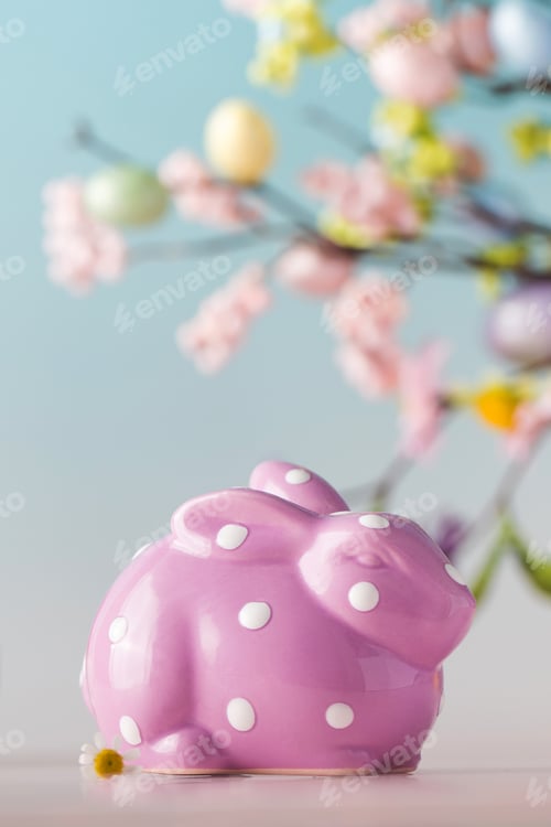 Preview: Lilac bunny on a blue background with a branch of flowers. Easter concept.