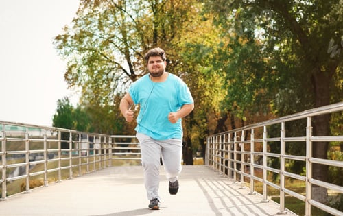 Preview: Young overweight man running outdoors. Fitness lifestyle