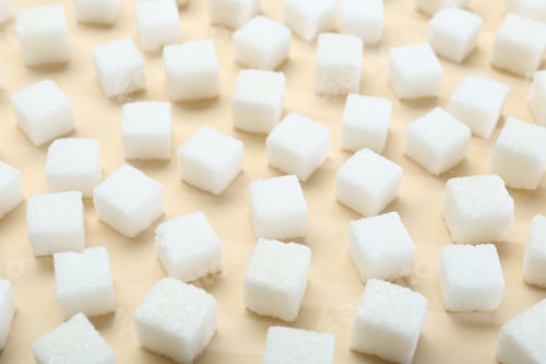 Preview: White sugar cubes on beige background, closeup