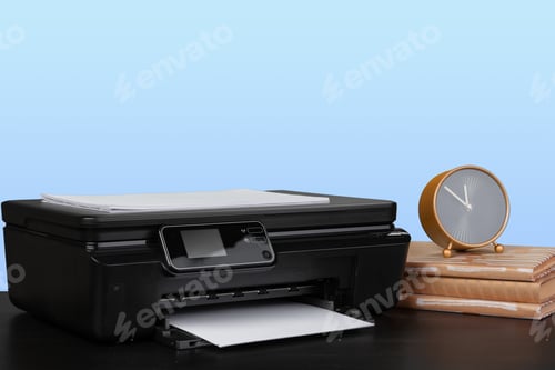 Preview: Compact laser printer on black desk against blue background