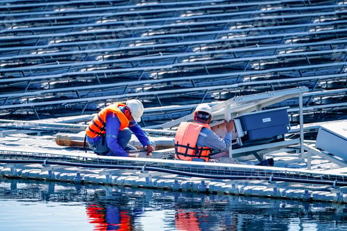 Preview: Local worker working at floating solar panels platform on the water of solar cell power plant.