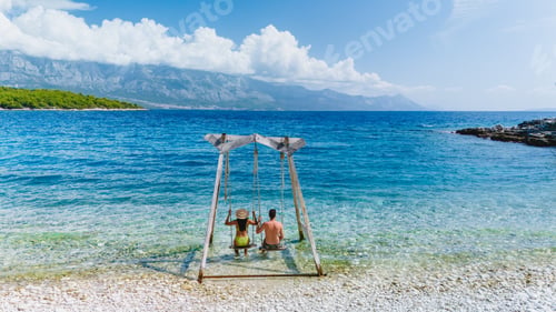 Preview: Relaxing on a swing by the crystal-clear waters of Brac Island, Croatia, under a sunny sky