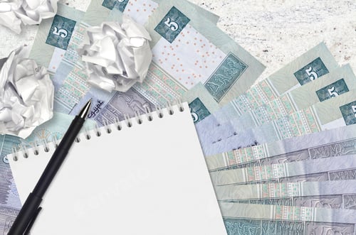 Preview: 5 Egyptian pounds bills and balls of crumpled paper with blank notepad