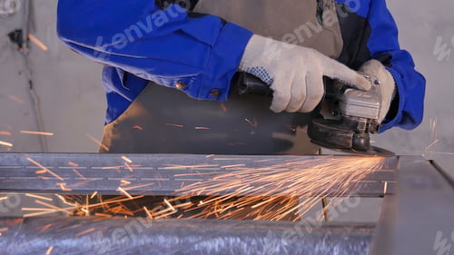 Preview: Craftsman sawing metal with disk grinder in workshop. Grinding metal with sparks flying. Electric