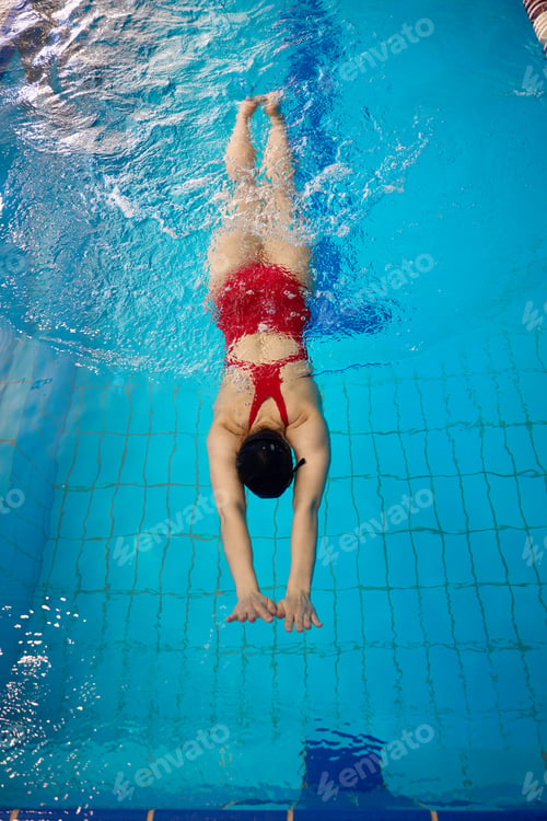 Preview: Experienced sportswoman exercising alone in sports pool