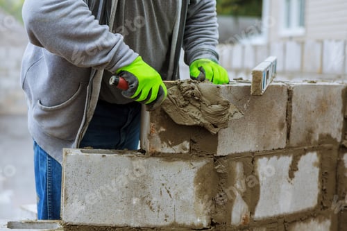 Preview: Mason lays down a wall of blocks. wall erection of blocks