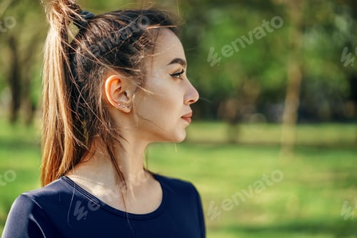 Preview: Portrait of a young smiling woman wearing sportswear in morning park