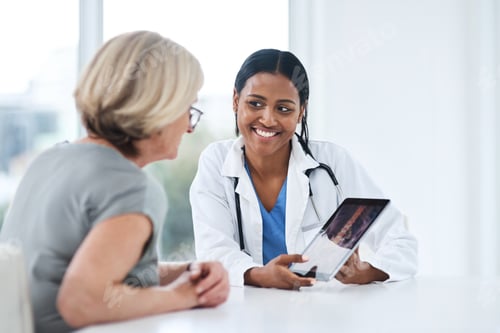 Preview: Shot of a young doctor using a digital tablet during a consultation with a senior woman