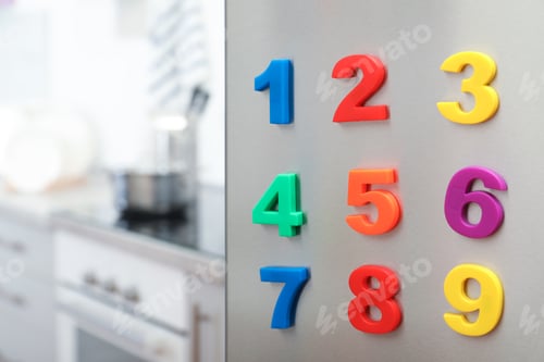 Preview: Colorful magnetic numbers on refrigerator door in kitchen. Space for text