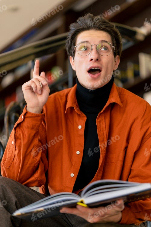 Preview: guy sits on the stairs and reads a book enthusiastically shocked by the plot of the events of story