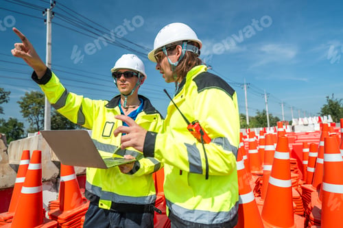 Preview: Two engineers in high visibility jackets and helmets operate a drone using a laptop