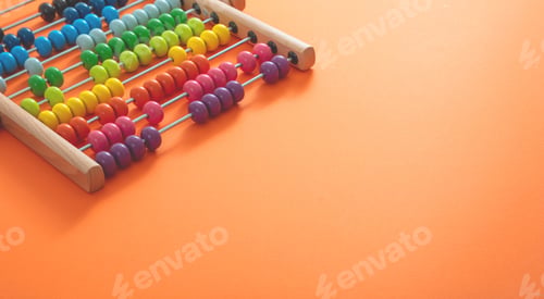 Preview: School abacus with colorful beads on orange color background, close up view
