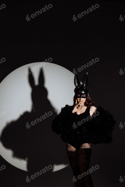 Preview: A woman in a black outfit with a rabbit mask on her face