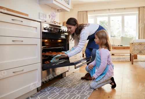 Preview: Shot of a mother and daughter inserting a tray of cupcakes into the oven