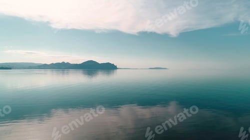 Preview: Mirrored water reflects blue sky with mountain horizon. Shot. Picturesque landscape with reflection