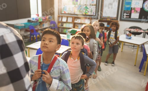 Preview: Front view of school kids standing and forming a queue in classroom at school