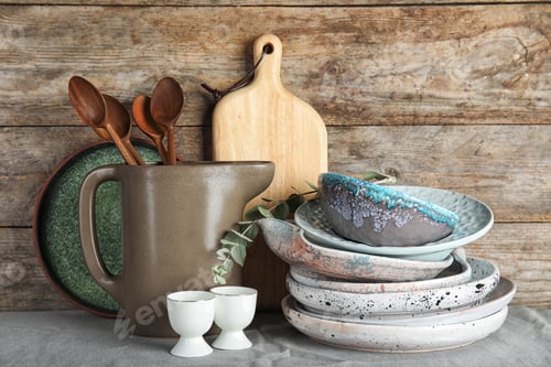 Preview: Composition with dishware and utensils on table against wooden background. Interior element
