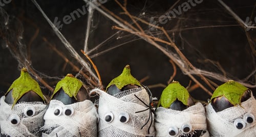 Preview: Halloween background. Spooky vegetables in medical bandages on a dark background. Halloween food.