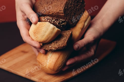 Preview: cut baguette and a loaf of rye bread on a wooden board and a red background in the background
