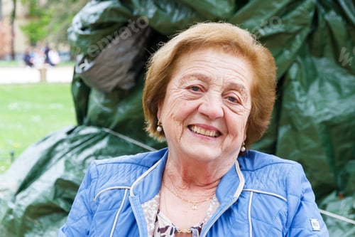 Preview: Portrait of a senior woman smiling looking at the camera sitting outside in a terrace of a bar