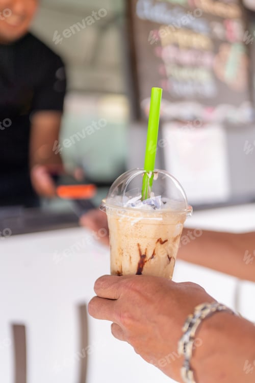 Preview: Man paying a delicious frappe in a food truck
