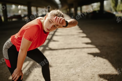 Preview: Tired fitness woman sweating taking a break after difficult training.