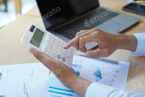 Preview: Asian male finance staff Calculating turnover with a calculator From the company's rapidly growing b