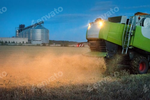 Preview: harvest, a combine in a wheat field, grain storage tanks
