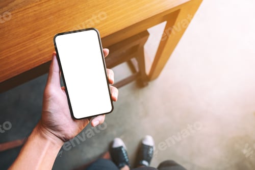 Preview: A man standing and holding black mobile phone with blank white screen