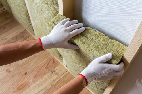 Preview: Close-up of worker hands in white gloves insulating rock wool insulation staff