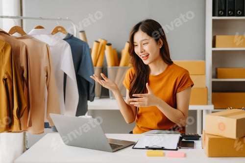 Preview: Young Asian business owner woman prepare parcel box and standing check online orders for deliver