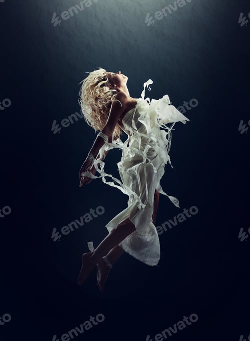 Preview: In her dreams...A gorgeous young woman levitating in the air isolated on black.