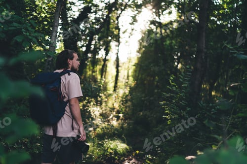 Preview: Anonymous man with backpack standing in forest