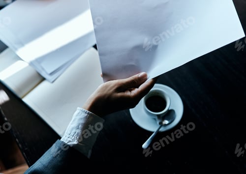 Preview: Business man in a cafe documents a cup of coffee on the table official work
