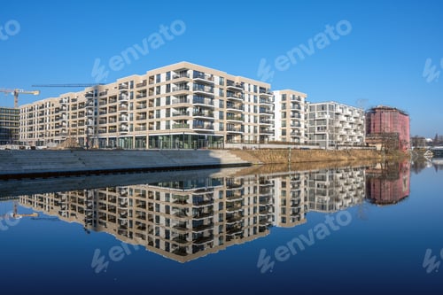 Preview: Modern apartment buildings with a perfect reflection in a small canal