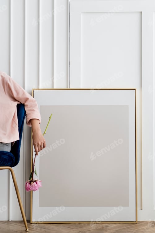 Preview: Woman holding a flower sitting by a frame mockup