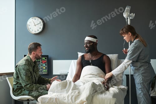 Preview: Young soldier in military uniform talking to his injured friend