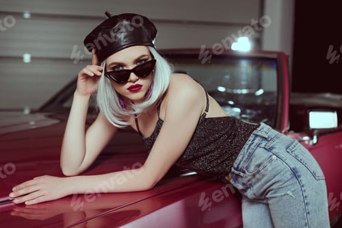 Preview: beautiful fashionable blonde girl in beret and sunglasses leaning at retro car and looking at camera